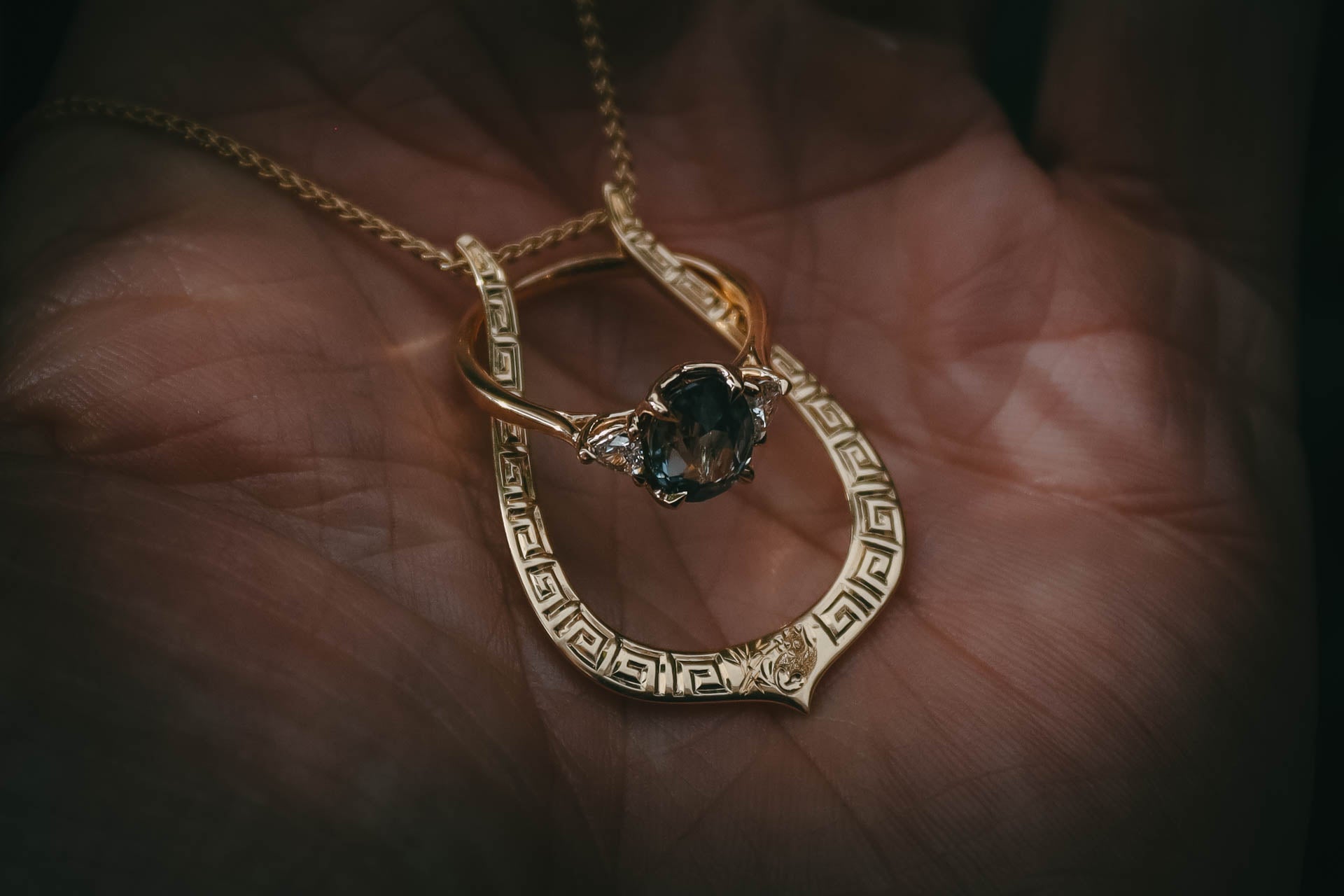 Hand engraved gold ring keeper pendant in hand