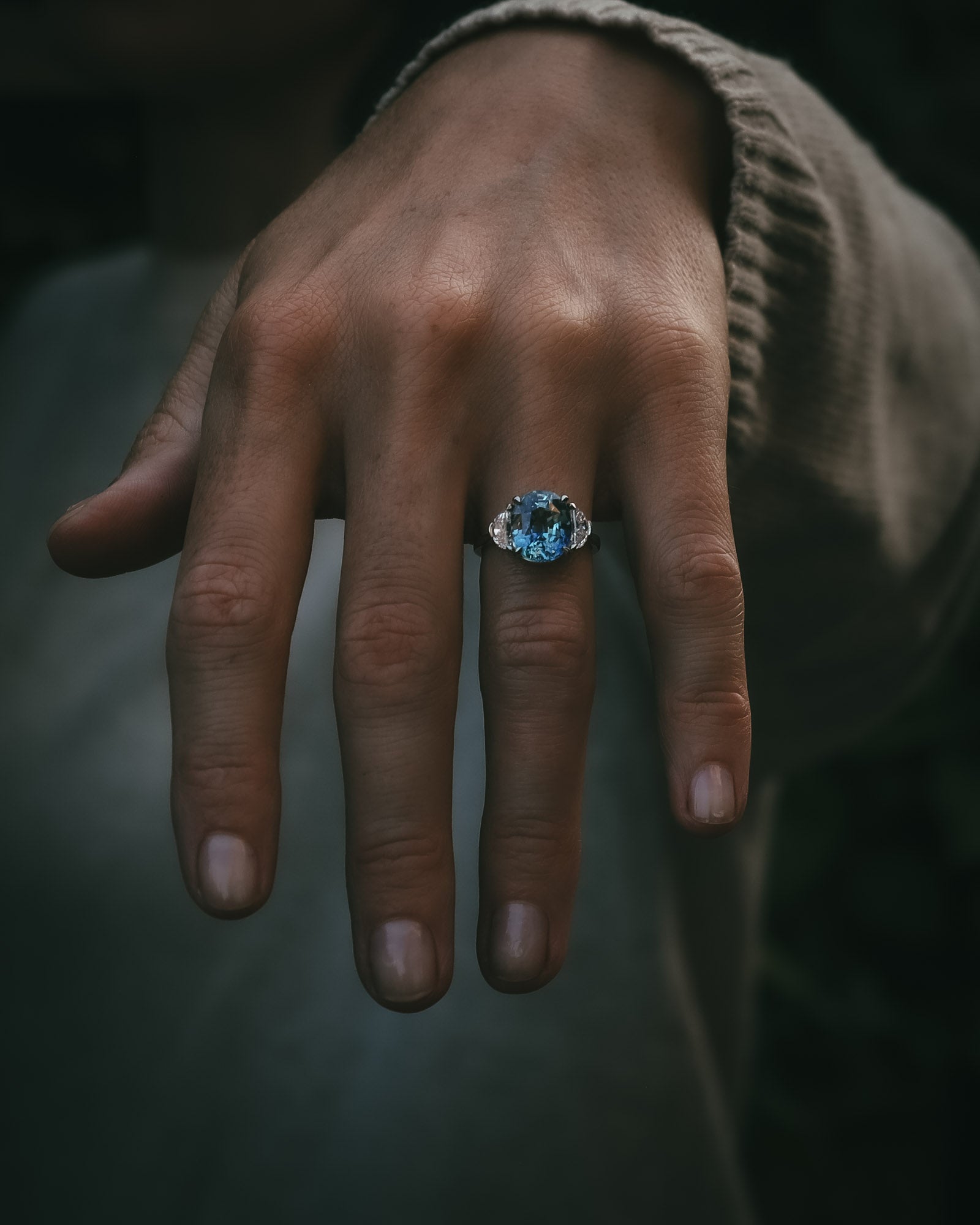 Ghlas oval teal sapphire and half-moon diamond ring in platinum, worn on the hand