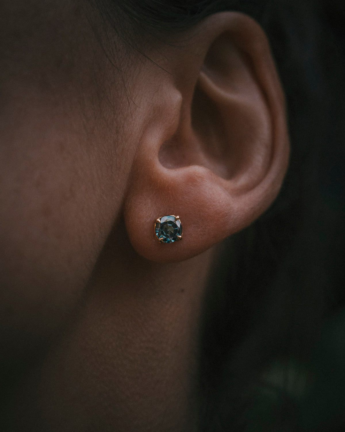 Petal round teal sapphire stud earrings in 18ct yellow gold, worn at the ear