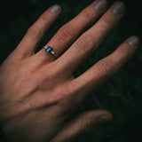 Sròn octagon step-cut teal sapphire ring in platinum with tapered baguette diamonds on hand