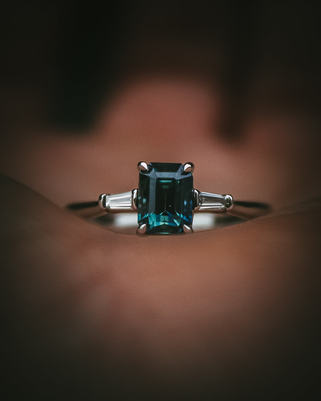 Sròn octagon step-cut teal sapphire ring front view in hand