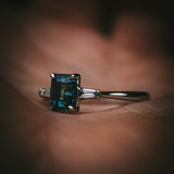 Sròn teal sapphire three-stone ring; platinum Arc setting side profile in hand