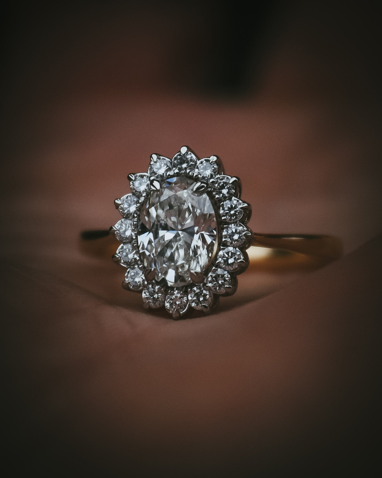 Flùr oval diamond cluster ring in 18ct yellow gold and platinum; front view in hand
