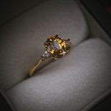 Fidra 2.04ct oval mixed-cut yellow and orange sapphire with trillion-cut diamond side stones