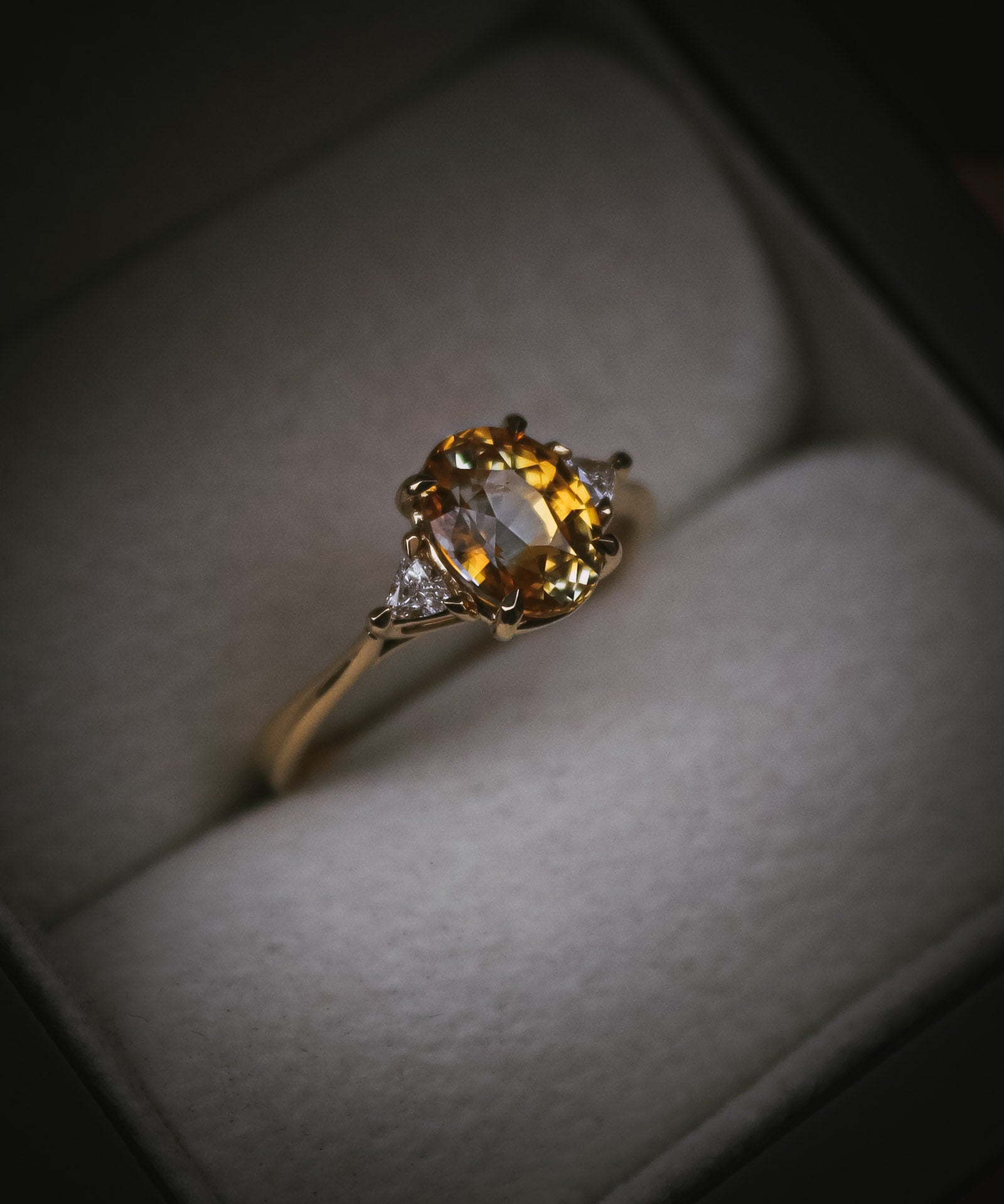Fidra 2.04ct oval mixed-cut yellow and orange sapphire with trillion-cut diamond side stones
