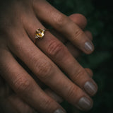 Fidra 2.04ct oval mixed-cut yellow and orange sapphire with trillion-cut diamond side stones on hand