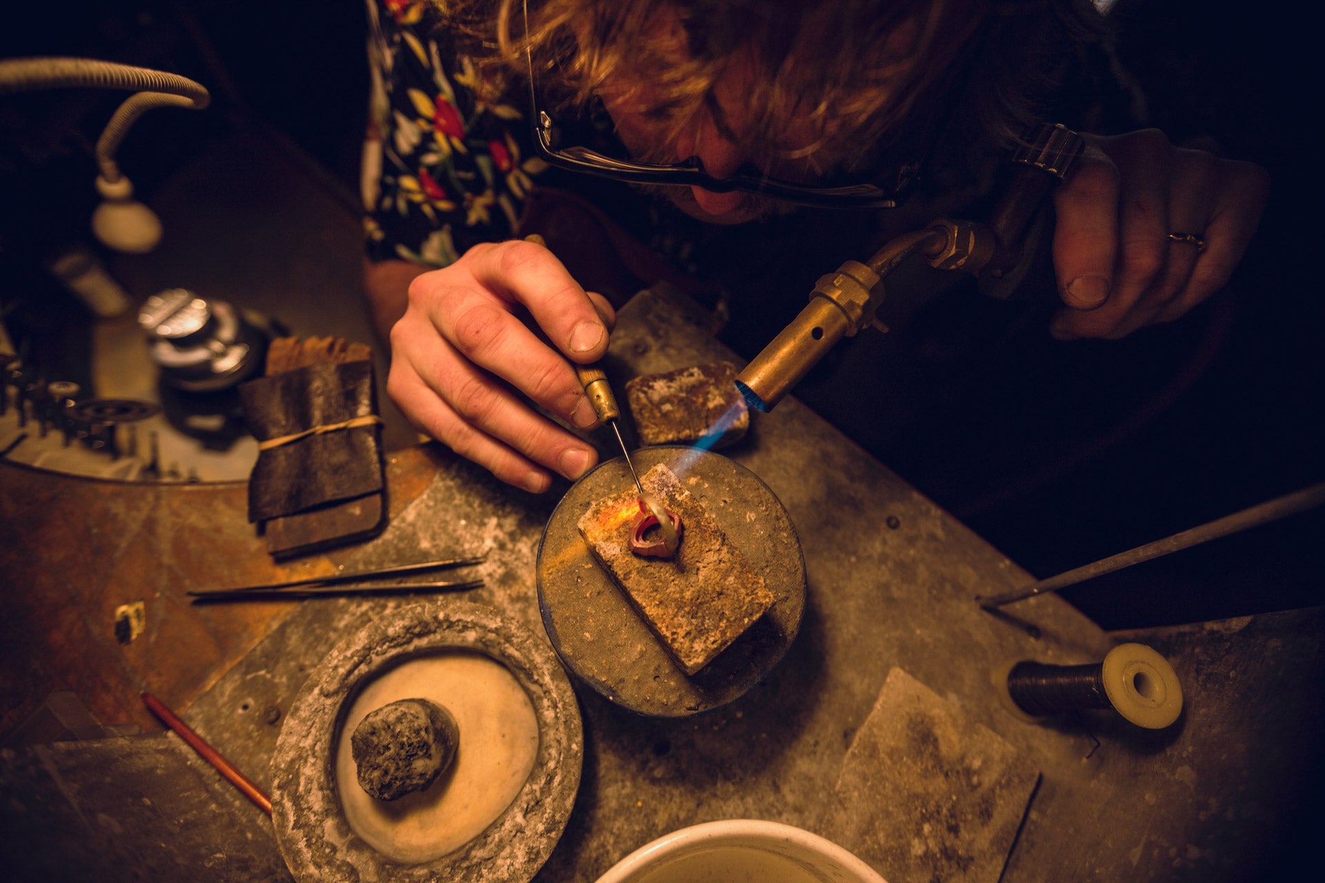 Master jeweller at workbench in the workshop