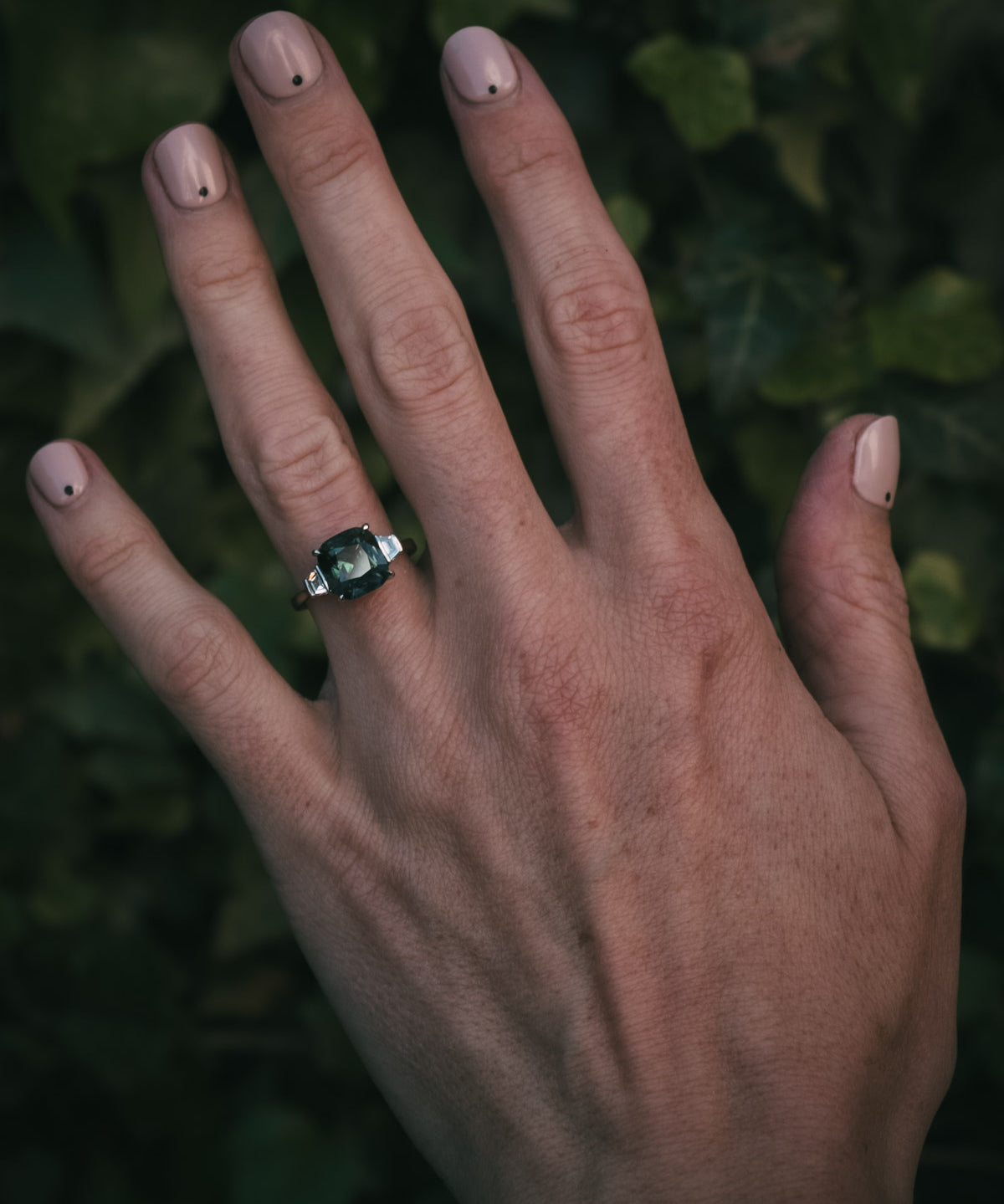 Teal sapphire and diamond bespoke engagement ring on hand